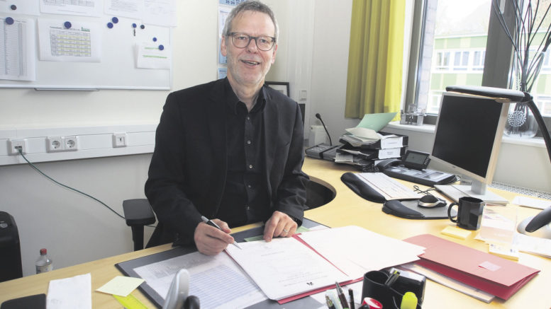 Wolfgang Bruhn bei einer seiner letzten Amtshandlungen am Schreibtisch im Schulleiterbüro: dem Unterschreiben von Zeugnissen. Foto: Wolfgang Becker